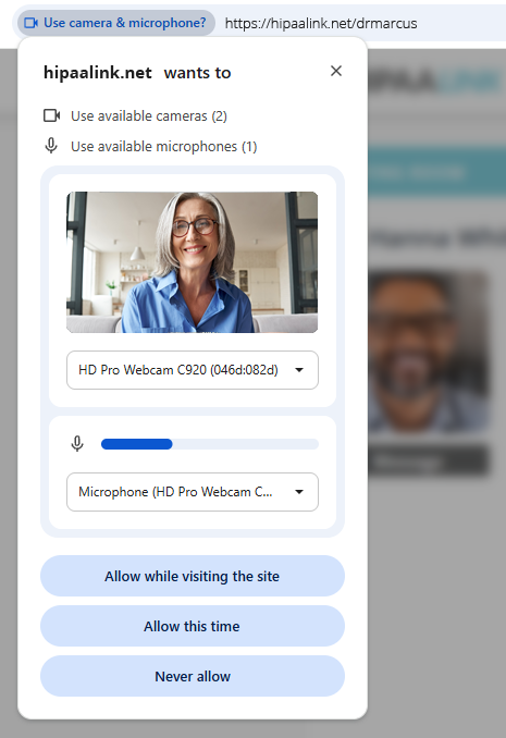 A browser permission bubble below the address bar, which reads hipaalink.net slash the provider name. The bubble is headed hipaalink.net wants to, and lists use available cameras and use available microphones. Below those a preview shows the person the camera can see, with a dropdown naming the webcam, then a microphone level meter with its own dropdown. Three buttons run along the bottom: Allow while visiting the site, Allow this time, and Never allow.