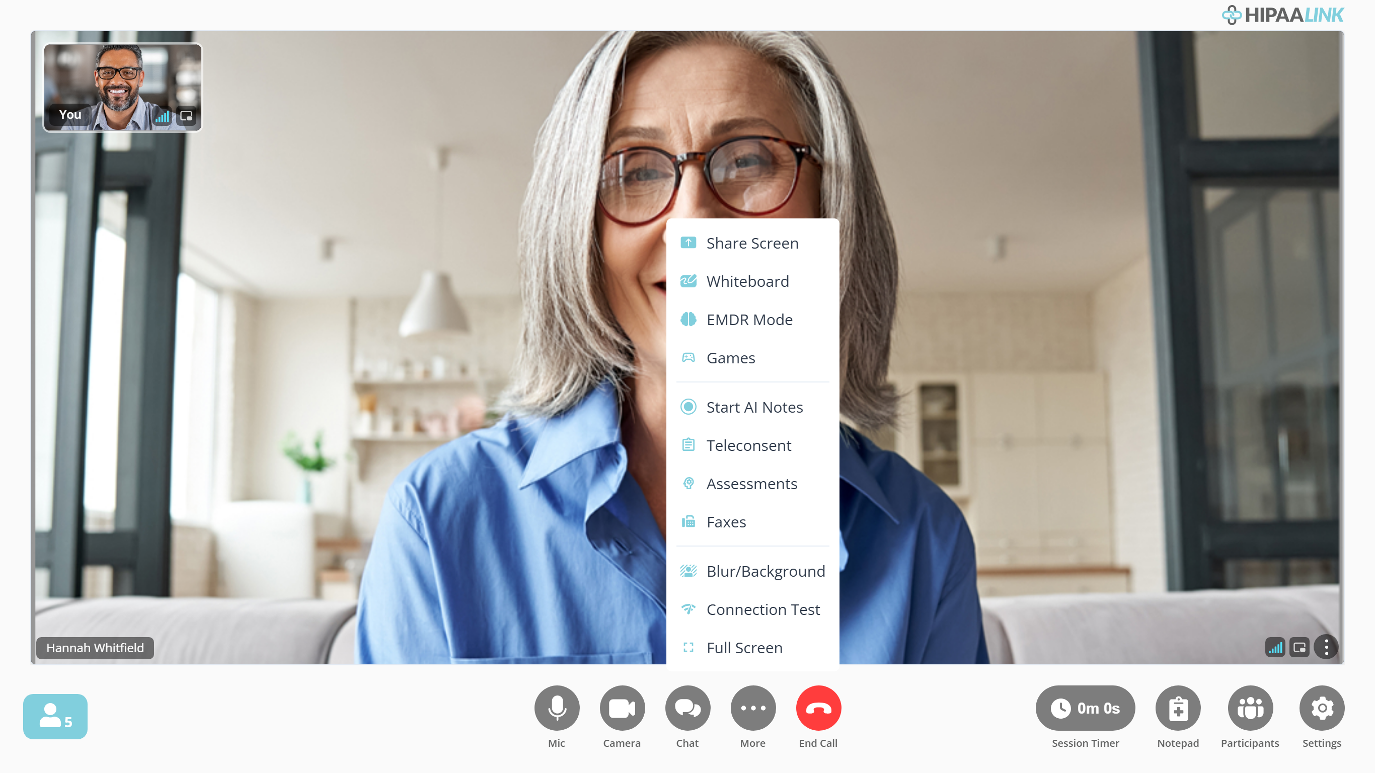 The same call screen with the More menu open. The menu is a white panel standing over the video directly above the More button, holding eleven items in three groups separated by thin lines: Share Screen, Whiteboard, EMDR Mode, Games; then Start AI Notes, Teleconsent, Assessments, Faxes; then Blur/Background, Connection Test, Full Screen. The client is still visible on either side of it.