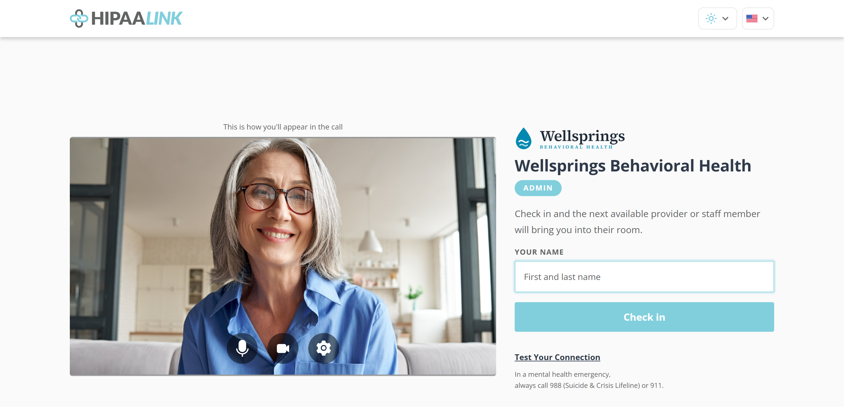 A full page check-in screen. On the left a large camera preview captioned This is how you will appear in the call, with microphone, camera and settings buttons over the bottom of it. On the right the clinic logo, the clinic name, a room name in a rounded tag, a line saying the next available provider or staff member will bring you into their room, a Your Name box, a Check in button, a Test Your Connection link and a crisis line note.